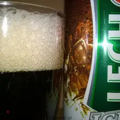 Szklanka z gęstą pianą obok puszki piwa Lech Premium. Idealne na orzeźwiający wieczór.