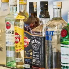 Rząd butelek alkoholi: Bacardi, Havana Club, Jack Daniel's, Absolut Vodka, Tanqueray. Idealne na mocne piwo i drinki.