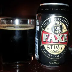 Szklanka ciemnego piwa obok puszki piwa Faxe Stout. Idealne na wieczór z dobrą książką.