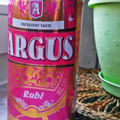 Puszka piwa Argus Rubi z napisem "Excellent Taste", obok zielona doniczka.