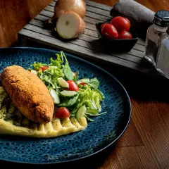 Kotlet schabowy z puree i sałatką, idealny do wyśmienitej wódki wyborowej.