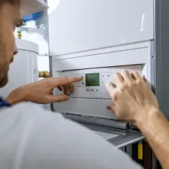 Technik reguluje piec gazowy. Sprawdza temperaturę, jakby szukał najlepszej **wino portada cena** dla swojego domu.