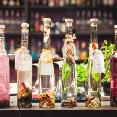 Sześć butelek z nalewkami, jedna z różową zawartością, druga z przyprawami. Zastanawiasz się, ile procent ma tequila?