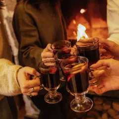 Ciepłe dłonie unoszą kubki z aromatycznym grzańcem przy kominku. Wesoła kijafa w gronie przyjaciół.