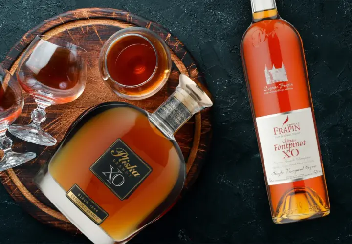 Butelka i kieliszki z bursztynowym brandy. To jest co to jest brandy - szlachetny trunek.