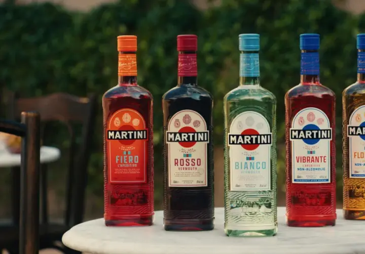 Pięć butelek Martini o różnych kolorach i smakach, stojących na stole na zewnątrz.