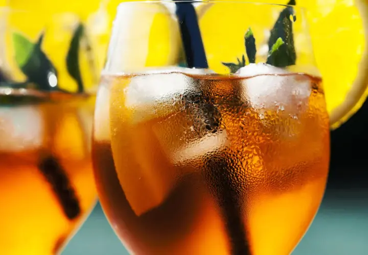 Orzeźwiający aperol bezalkoholowy z lodem, plasterkiem pomarańczy i miętą. Idealny na letnie popołudnie.