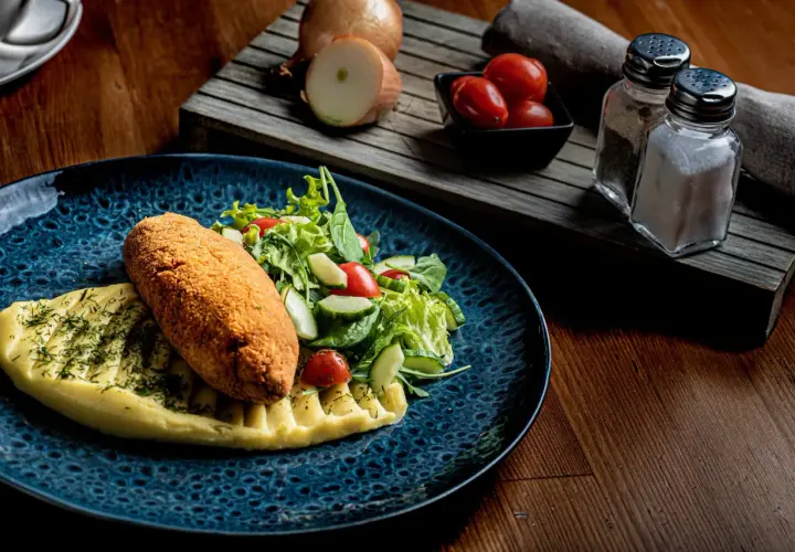 Kotlet schabowy z puree i sałatką, idealny do wyśmienitej wódki wyborowej.