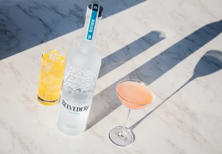 Wódka Belvedere 0.7 cena: elegancka butelka, drink w kieliszku i szklanka z lodem na marmurowym blacie.