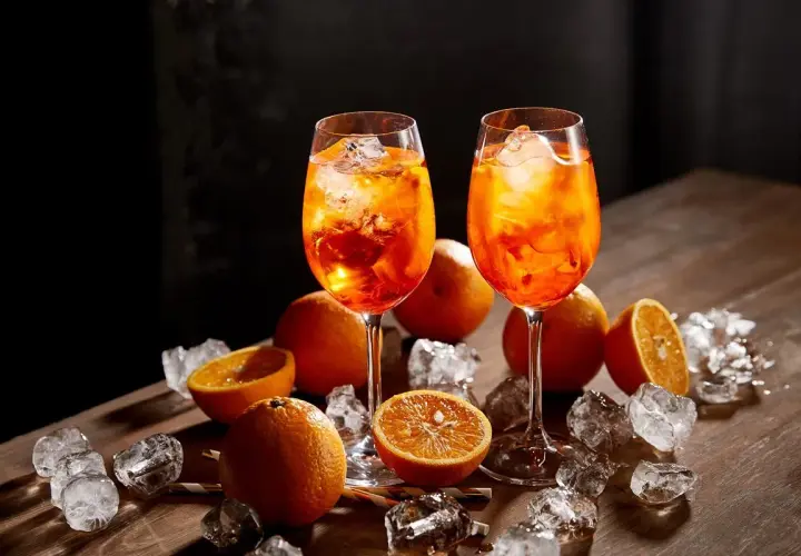 Dwa drinki Aperol Spritz z lodem i pomarańczą. Sprawdź atrakcyjną aperol cena!