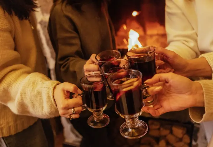 Ciepłe dłonie unoszą kubki z aromatycznym grzańcem przy kominku. Wesoła kijafa w gronie przyjaciół.