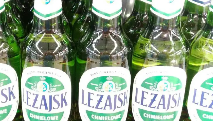 Rząd zielonych butelek piwa Leżajsk Chmielowe Pils. Idealne na letnie wieczory.