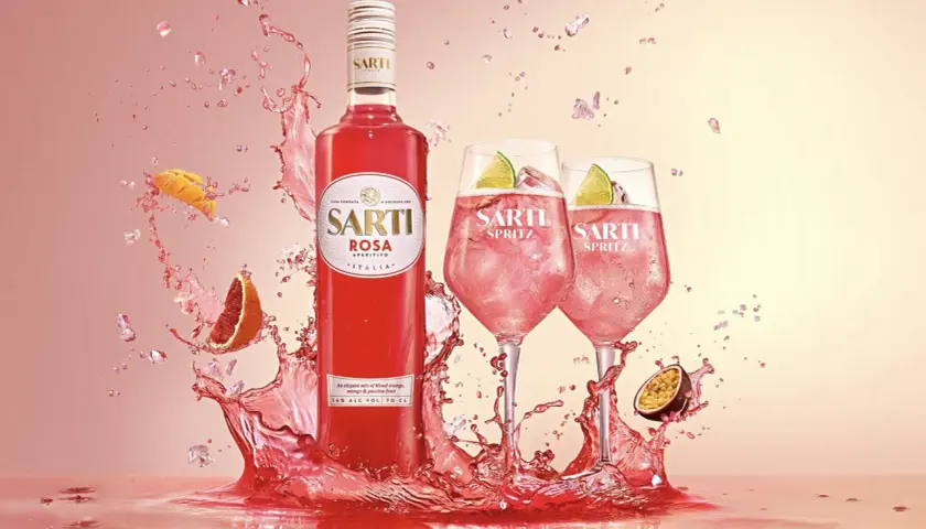 Sarti Spritz w towarzystwie owoców i orzeźwiających bryzgów. Idealny aperitif na letnie wieczory.