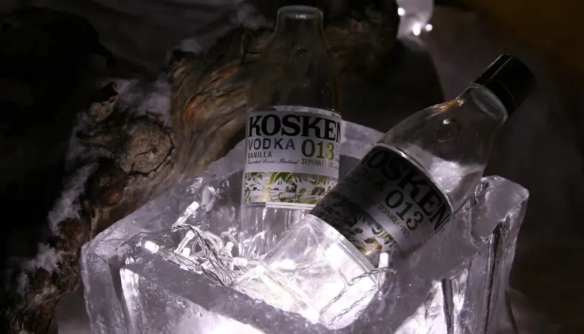 Dwie butelki wódki Koskenkorva w lodowym wiaderku, ozdobione lampkami.