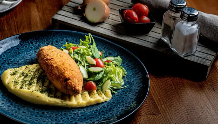 Kotlet schabowy z puree i sałatką, idealny do wyśmienitej wódki wyborowej.