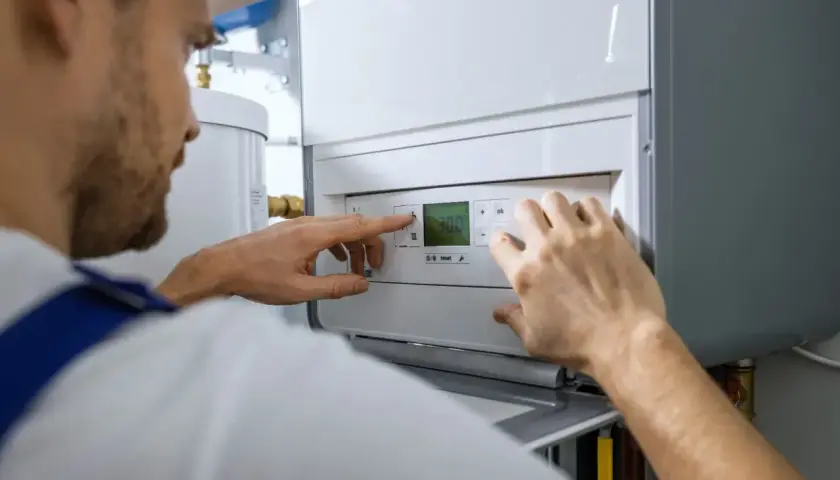 Technik reguluje piec gazowy. Sprawdza temperaturę, jakby szukał najlepszej **wino portada cena** dla swojego domu.