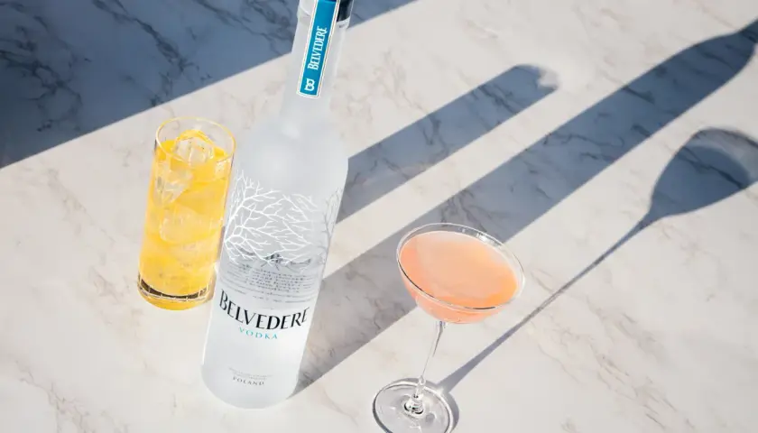 Wódka Belvedere 0.7 cena: elegancka butelka, drink w kieliszku i szklanka z lodem na marmurowym blacie.
