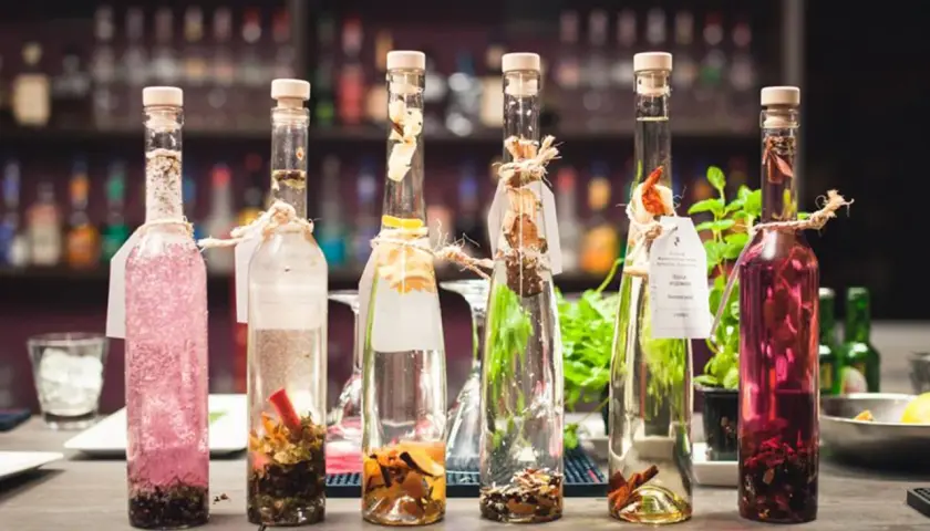 Sześć butelek z nalewkami, jedna z różową zawartością, druga z przyprawami. Zastanawiasz się, ile procent ma tequila?
