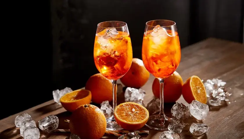 Dwa drinki Aperol Spritz z lodem i pomarańczą. Sprawdź atrakcyjną aperol cena!