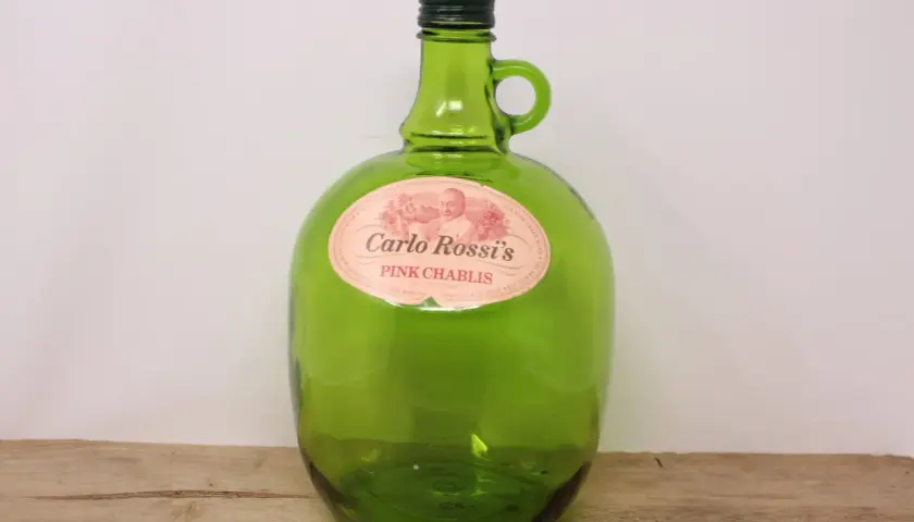 Zielona, szklana butelka Carlo Rossi Pink Chablis z uchwytem.