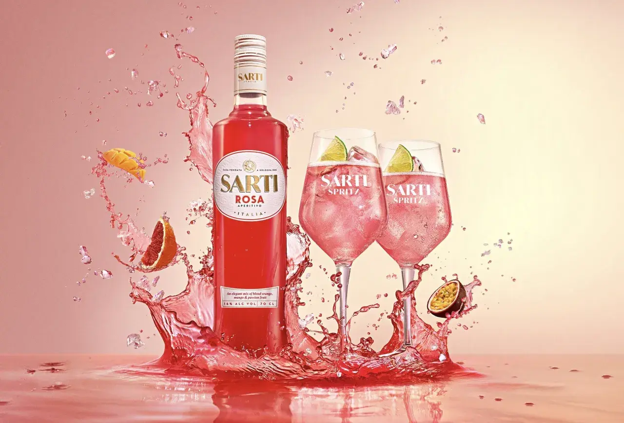 Sarti Spritz w towarzystwie owoców i orzeźwiających bryzgów. Idealny aperitif na letnie wieczory.