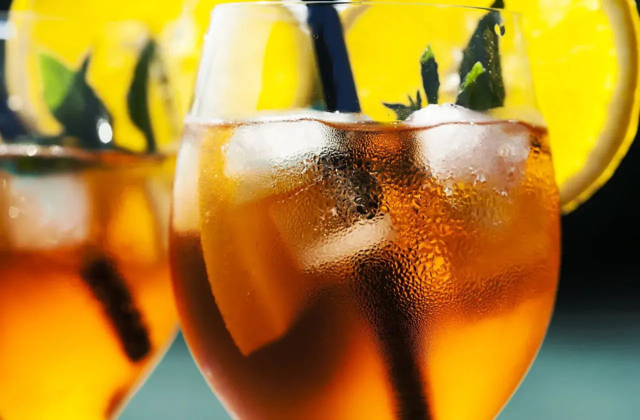Orzeźwiający aperol bezalkoholowy z lodem, plasterkiem pomarańczy i miętą. Idealny na letnie popołudnie.