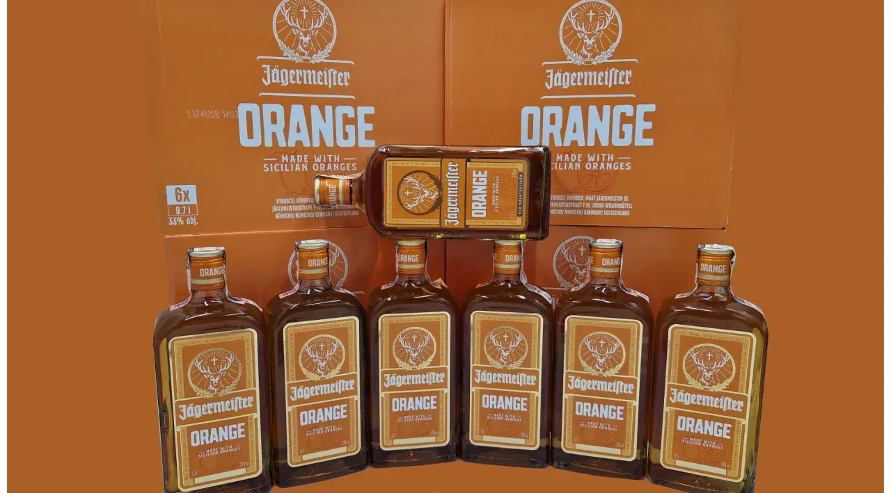 Jägermeister Orange, jeden z rodzajów Jägermeister, w butelkach i kartonach, z pomarańczowym motywem.