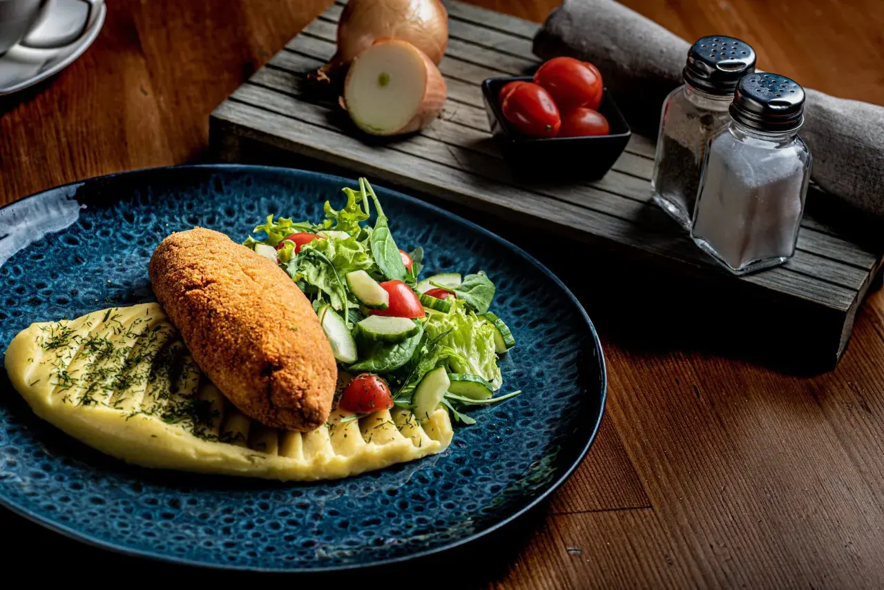 Kotlet schabowy z puree i sałatką, idealny do wyśmienitej wódki wyborowej.