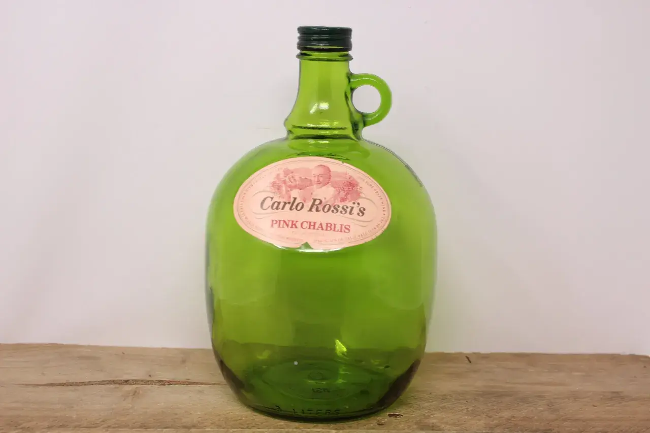 Zielona, szklana butelka Carlo Rossi Pink Chablis z uchwytem.