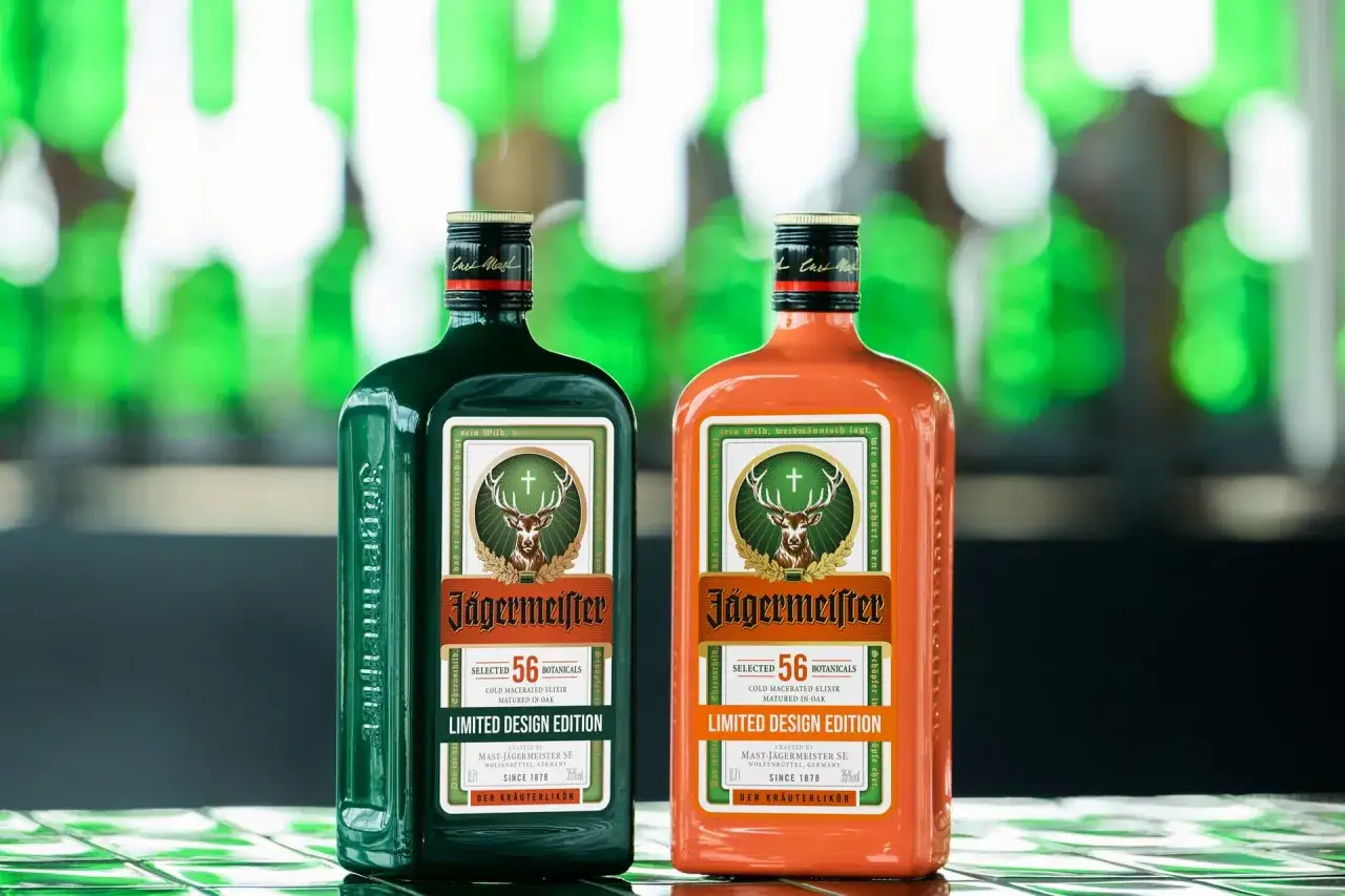 Dwie butelki Jägermeistera: klasyczna zielona i pomarańczowa edycja limitowana. Poznaj różne rodzaje Jägermeistera.