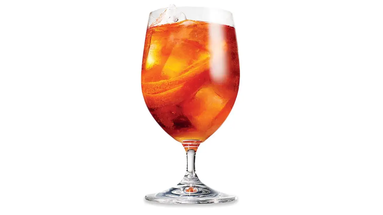 Orzeźwiający drink z lodem i plasterkami pomarańczy, idealny na letnie popołudnie. Smakuje jak Martini Rosso.
