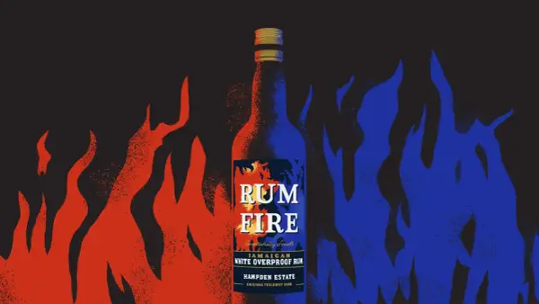 Butelka rumu "Rum Fire" otoczona płomieniami. Dunder w ogniu, czerwonym i niebieskim.